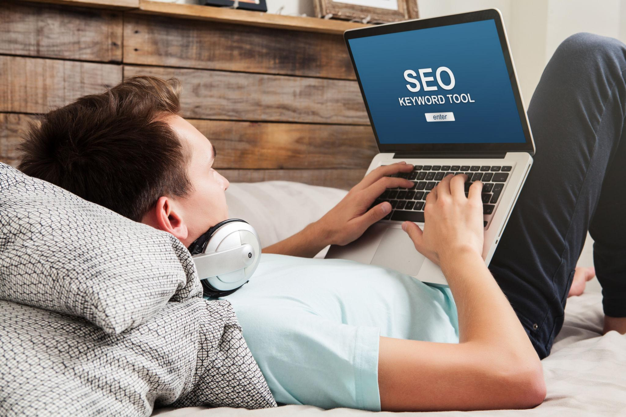 Man using a laptop to do SEO keyword work on a website
