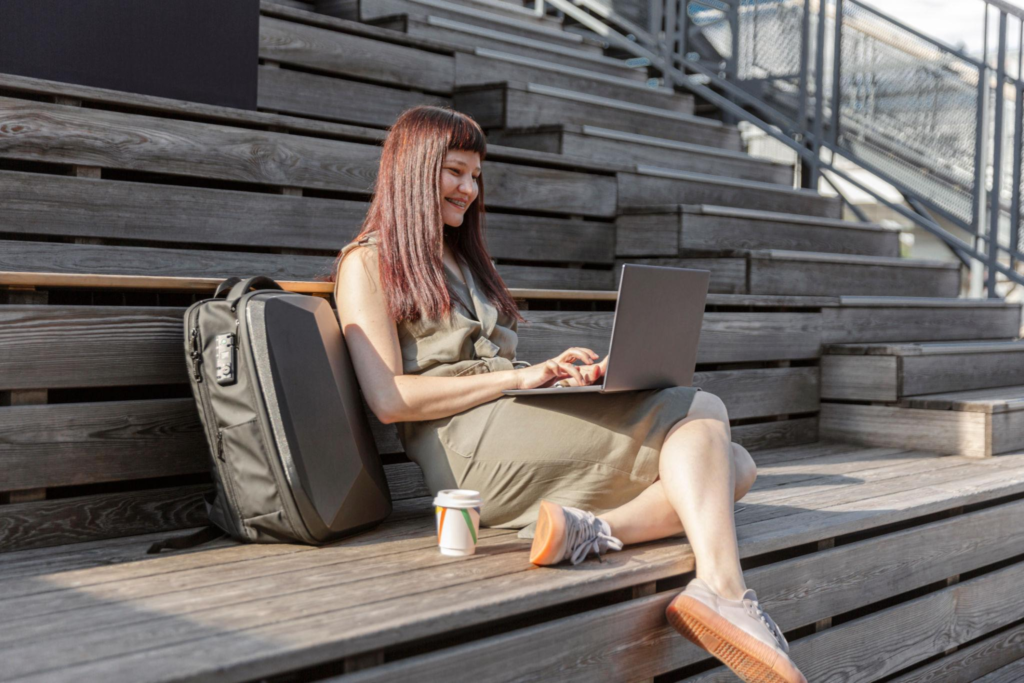 Positive female blogger or freelancer types text of publication on laptop computer